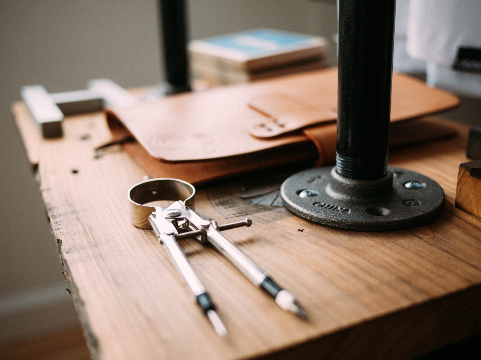 Un établi en bois avec un compas, une pochette en cuir et des outils d'artisan