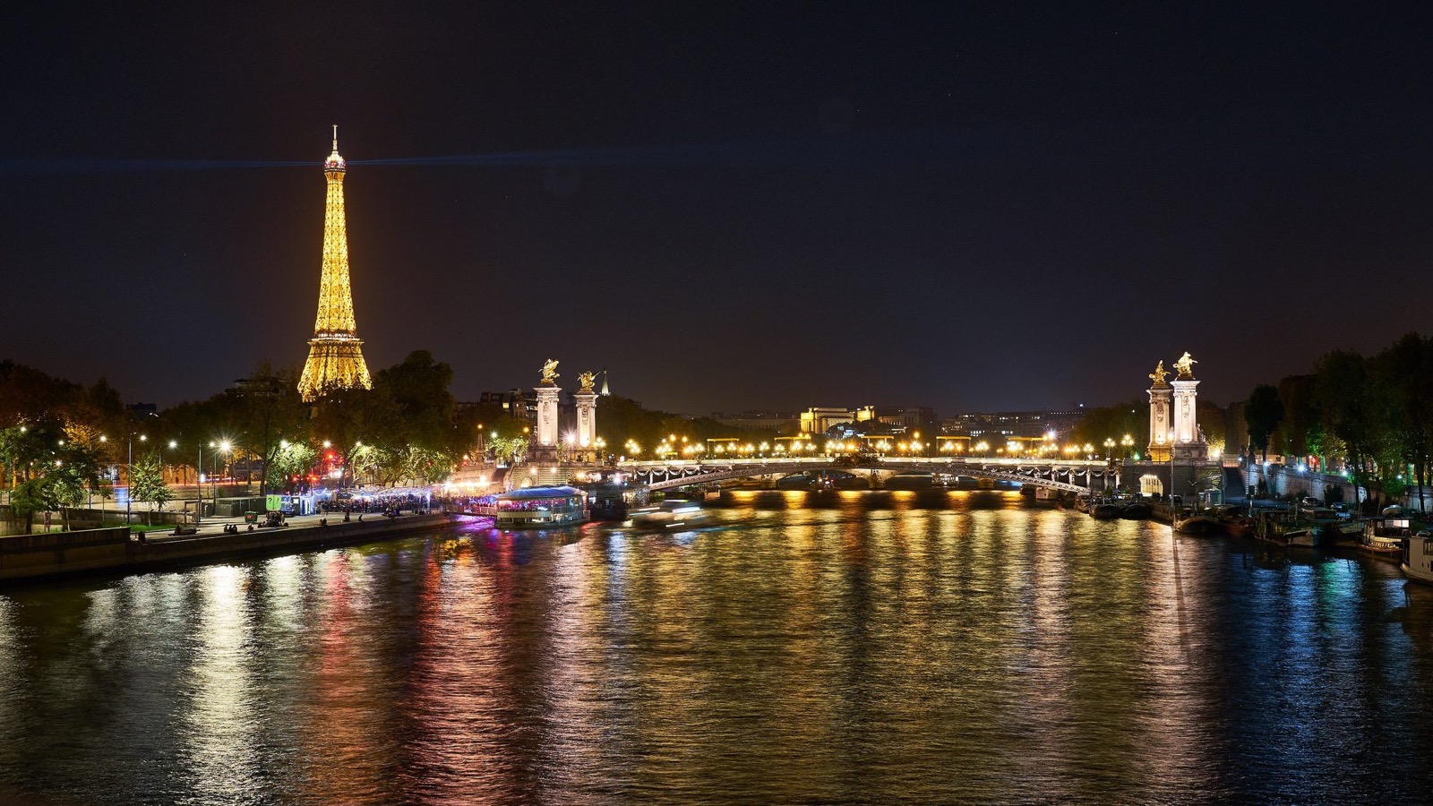La Seine de nuit à Paris, la tour Eiffel illuminée et le pont Alexandre-III