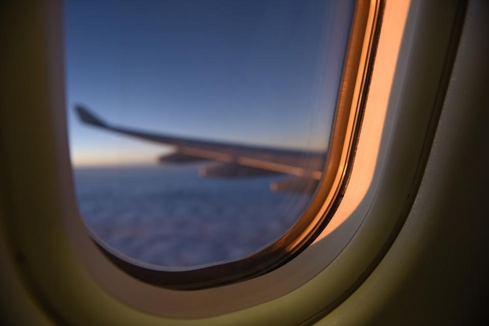 Illustration du thème voyage : une aile d'avion vue par le hublot